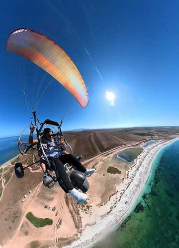 Tandem paramotor flight over the Sinis Coast at sunset
