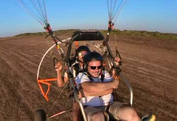 Tandem paramotor flight over the Sinis Coast at sunset